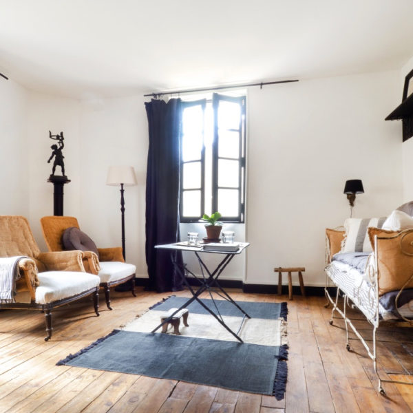 Woonkamer met openstaand raam en brocante inrichting