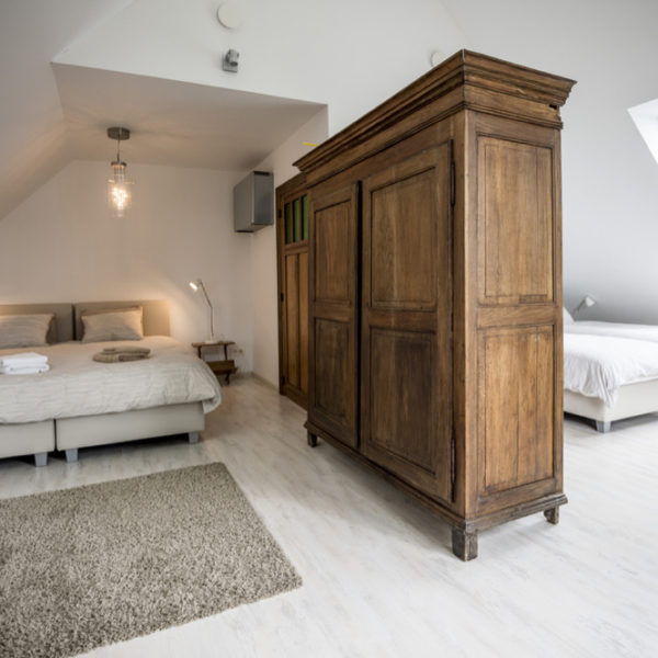 Slaapkamer met vier bedden, gescheiden door kasten