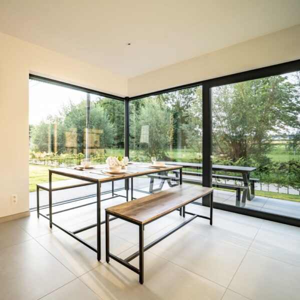 Stalen eethoek met houten blad voor metersgrote ramen