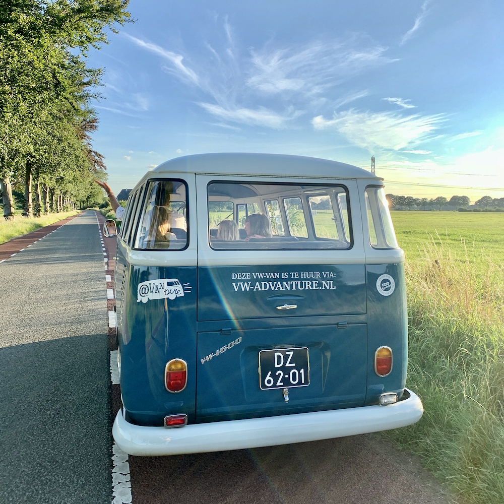 Blauw Volkswagen busje bij zonsondergang