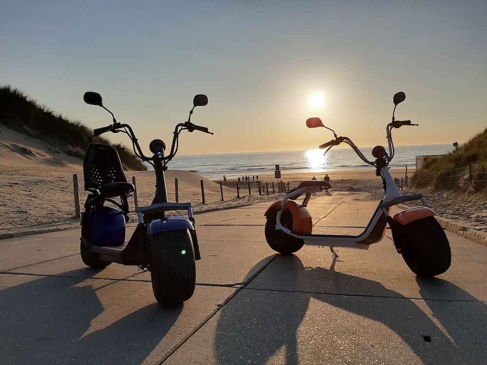 E-scooters bij zonsondergang aan zee