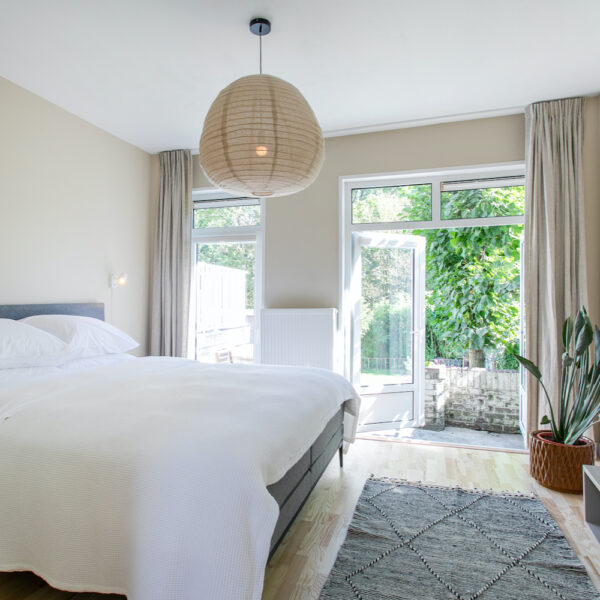 Slaapkamer met openslaande tuindeuren in de B&B in Amsterdam