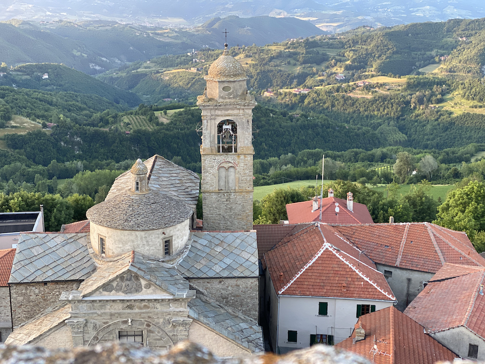 Historisch dorpje met kerktoren in groene heuvels in italië